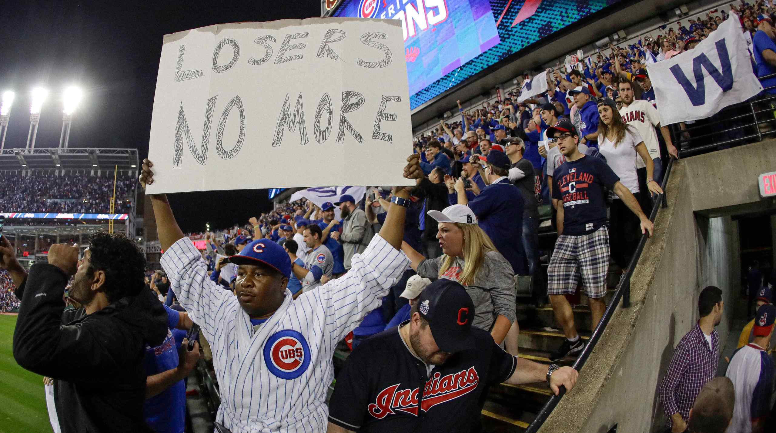 A Chicago Cubs fan holding a sign that reads Losers No More.